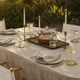 A beautifully set summer dining table for six with brass accents and natural light
