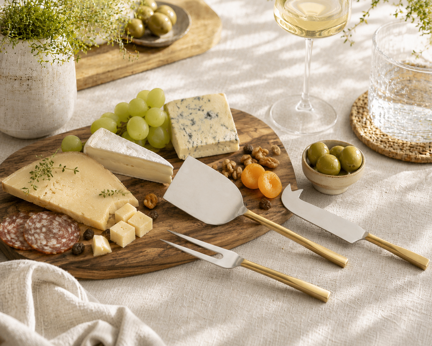 Aline Stainless Steel Cheese Cutlery Set of 4 Pieces Handcrafted in Stainless Steel and Brass Gold in a Mediterranean scene with a Marble Cheese Serving Board