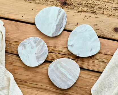Four marble-patterned coasters irregular shape from What a Host Home