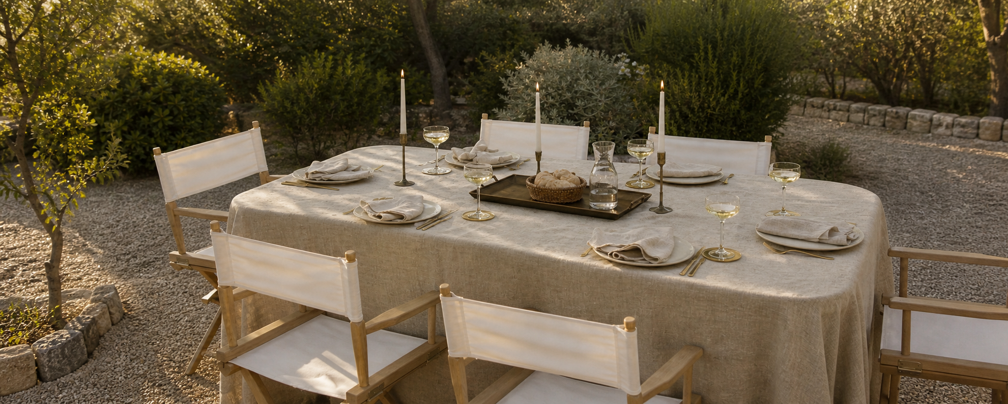 Outdoor Alfresco dining table with gold candle holders, gold handcrafted coasters, and natural fabric table textiles